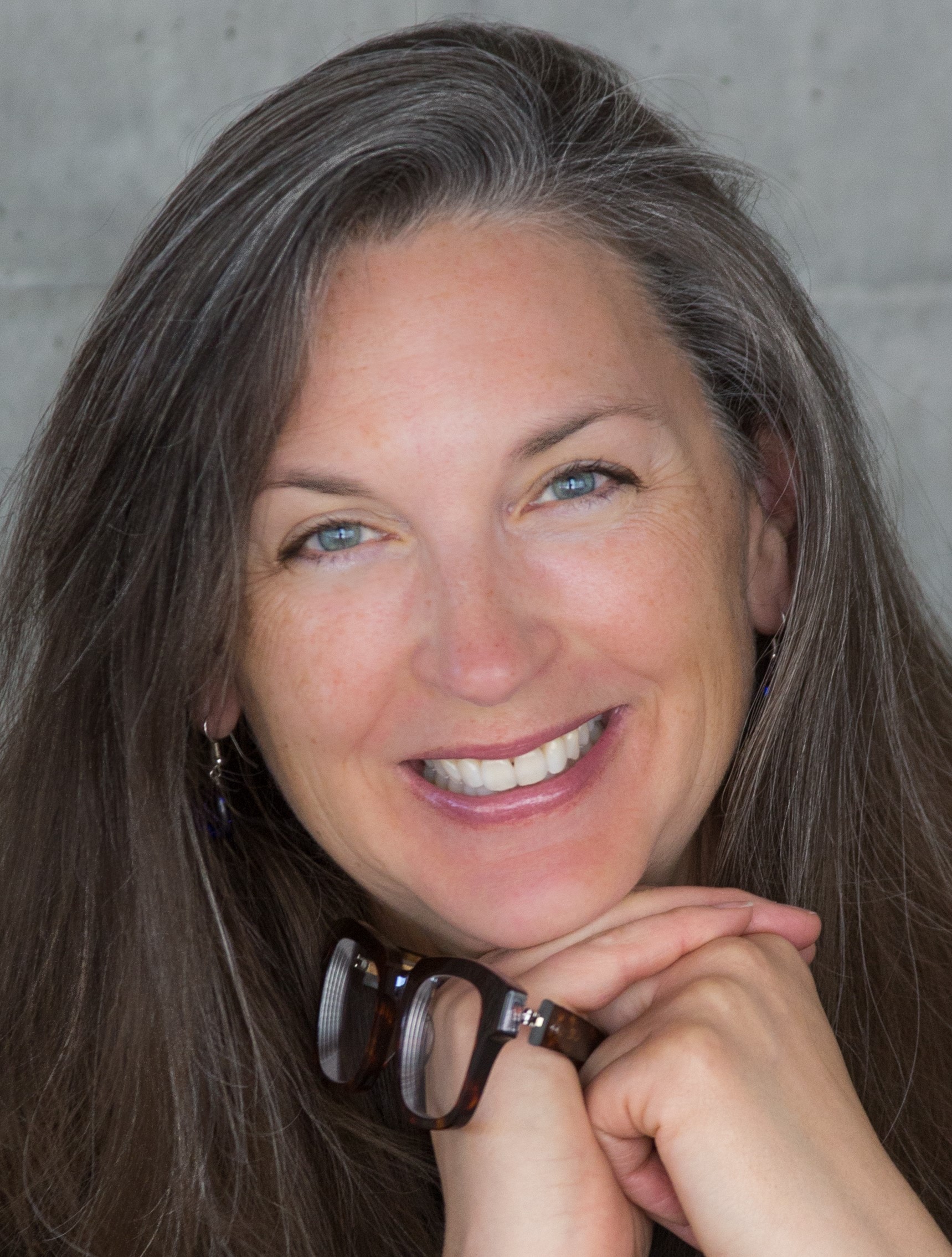 Dr. Christine Girard, woman smiling with glasses in her hand
